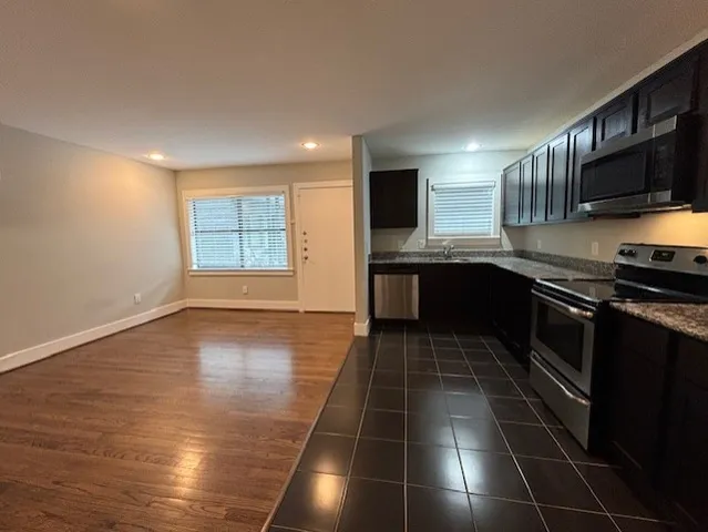 a kitchen with stainless steel appliances a stove a sink and a microwave