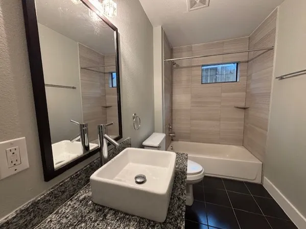 a bathroom with a sink a toilet a mirror and shower