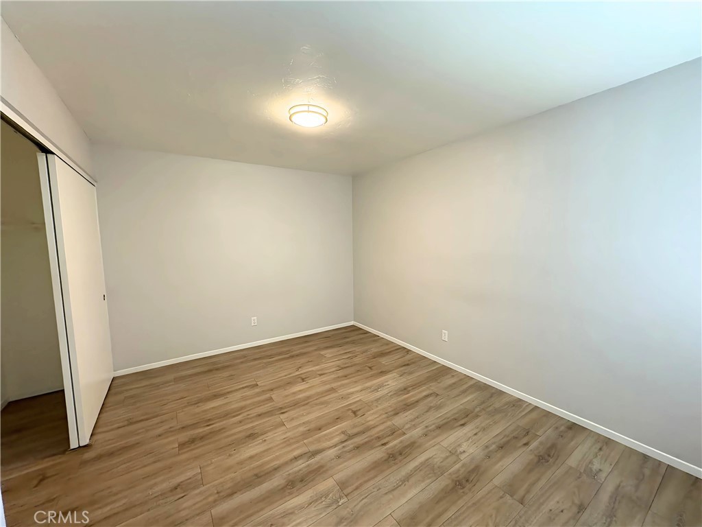 6635 Geranium Place Riverside, CA 92503 - Photo 9 of 15 an empty room with wooden floor and door