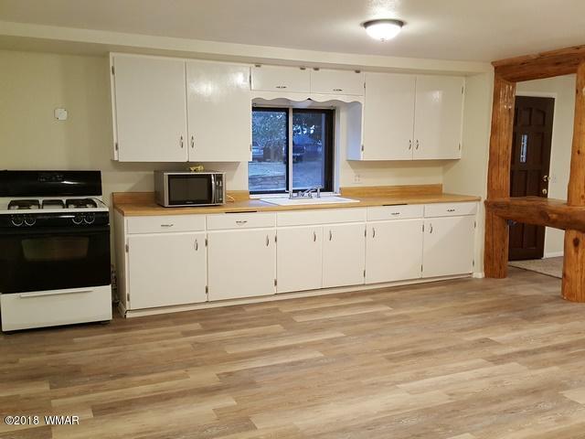 1128 East Maricopa Drive Springerville, AZ 85938 - Photo 16 of 28 a kitchen with granite countertop a stove and a sink
