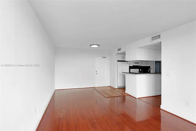 a view of a kitchen with a sink and a refrigerator