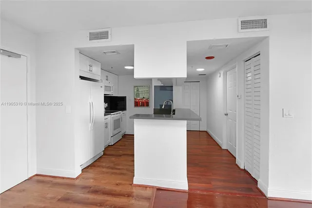 a view of kitchen with wooden floor and electronic appliances