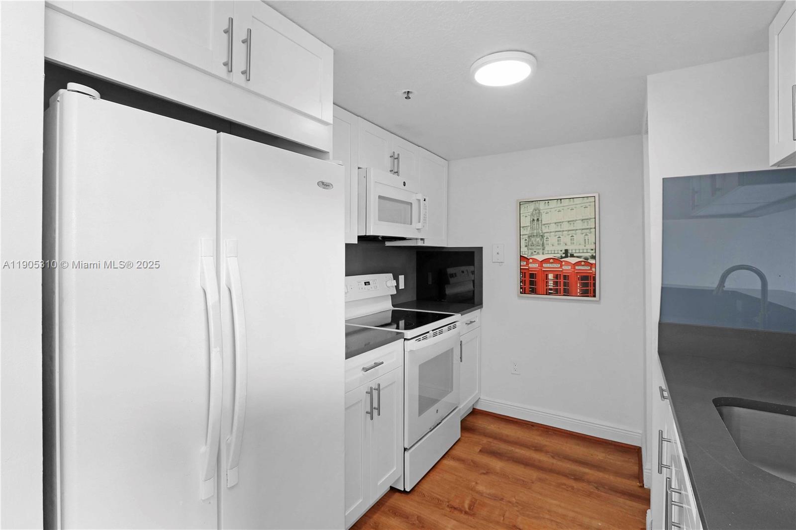 816 Northwest 11th Street, Unit 610 Miami, FL 33136 - Photo 16 of 28 a kitchen with stainless steel appliances a refrigerator sink and white cabinets