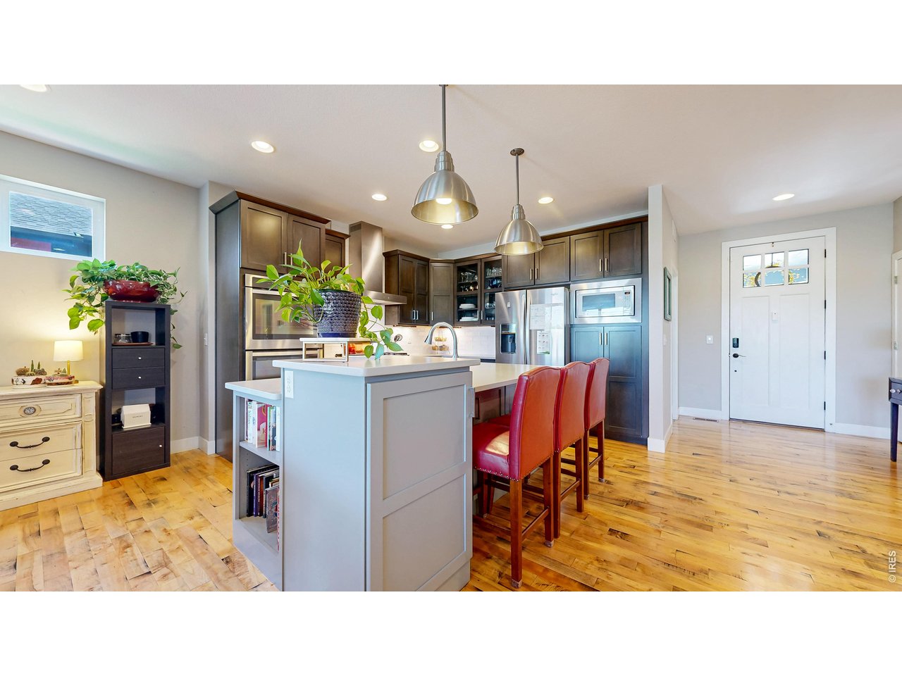 6990 Toponas Court Timnath, CO 80547 - Photo 11 of 44 a kitchen with stainless steel appliances kitchen island granite countertop a refrigerator and a dining table