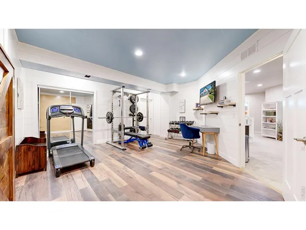 a living room with furniture and a gym machine