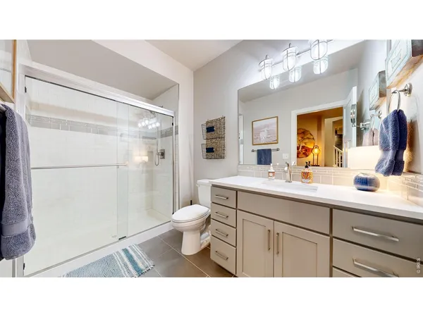 a bathroom with a sink a toilet a mirror and shower