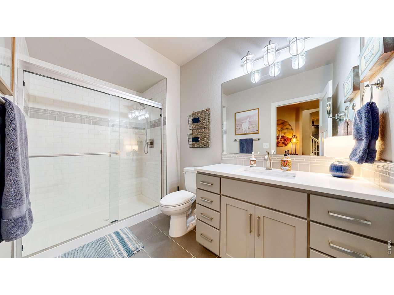 6990 Toponas Court Timnath, CO 80547 - Photo 29 of 44 a bathroom with a sink a toilet a mirror and shower
