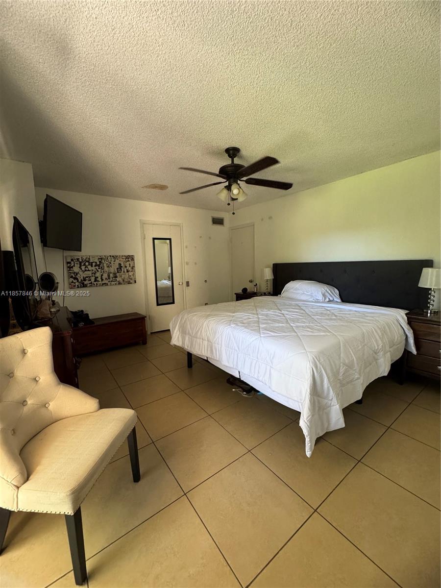 6445 Southwest 116th Place, Unit A Miami, FL 33173 - Photo 13 of 25 a bedroom with a bed and a couch