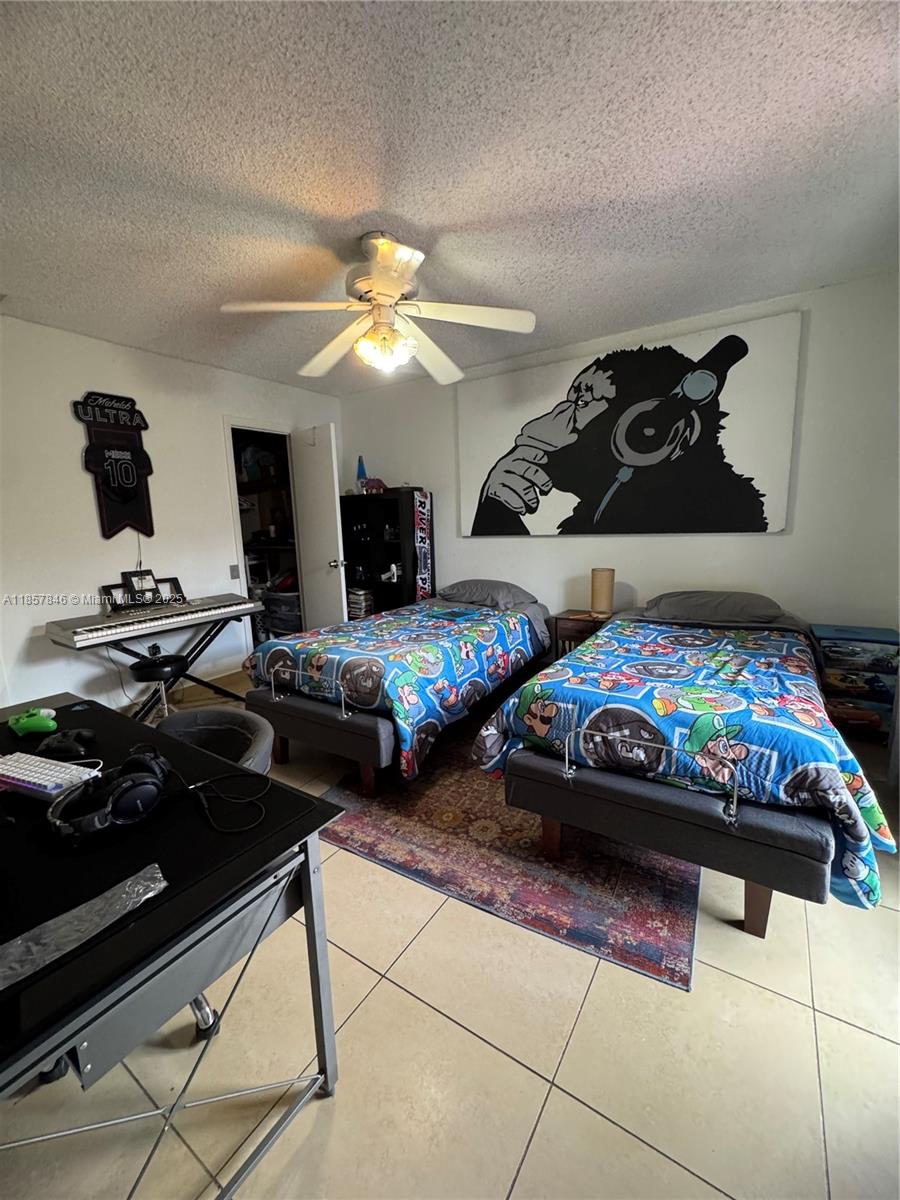 6445 Southwest 116th Place, Unit A Miami, FL 33173 - Photo 19 of 25 a bedroom with two beds and a chandelier