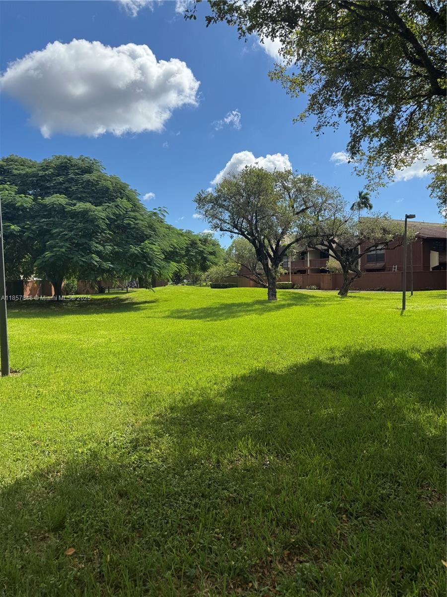 6445 Southwest 116th Place, Unit A Miami, FL 33173 - Photo 25 of 25 a view of a green yard with a house