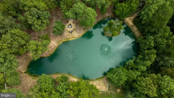 an aerial view of residential house with outdoor space and trees all around