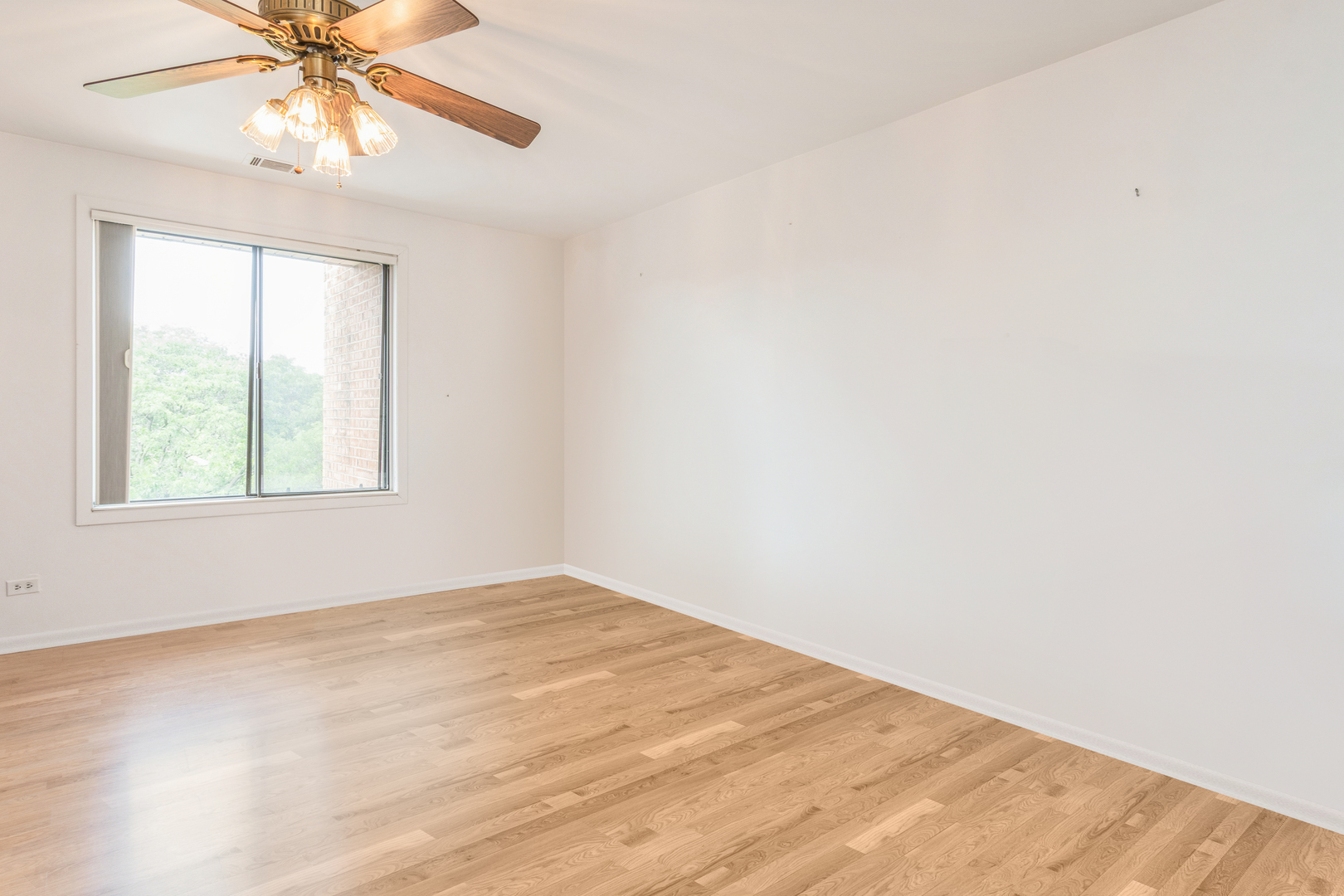 709 79th Street, Unit 401 Darien, IL 60561 - Photo 17 of 20 an empty room with a window and a fan