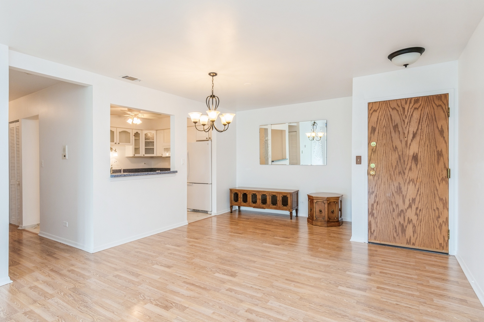 709 79th Street, Unit 401 Darien, IL 60561 - Photo 7 of 20 a view of a livingroom with wooden floor and a kitchen space