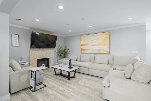 a living room with furniture a fireplace and a flat screen tv