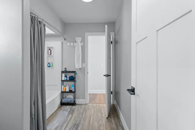 a view of a hallway with wooden floor and closet