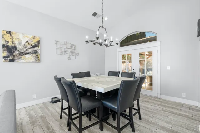 a view of a dining room with furniture a chandelier and wooden floor
