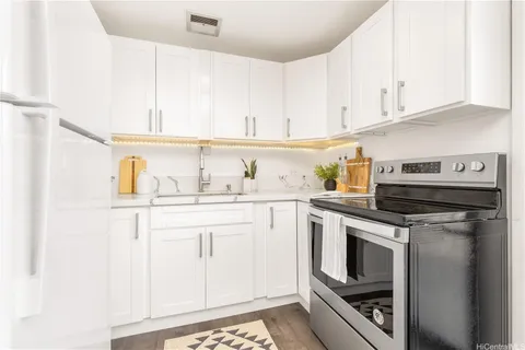 a kitchen with white cabinets and appliances