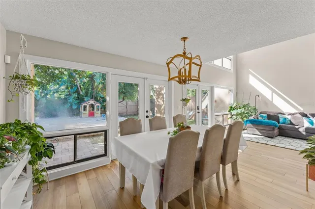 a dining room with wooden floor table and chairs