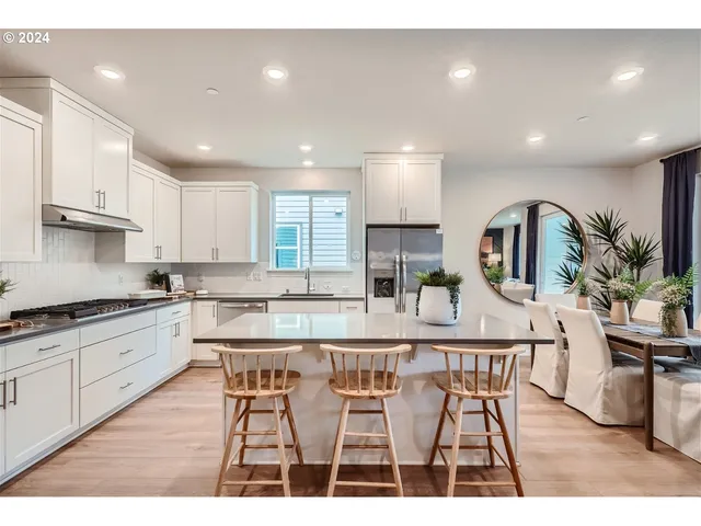 a kitchen with a sink stove and wooden floor