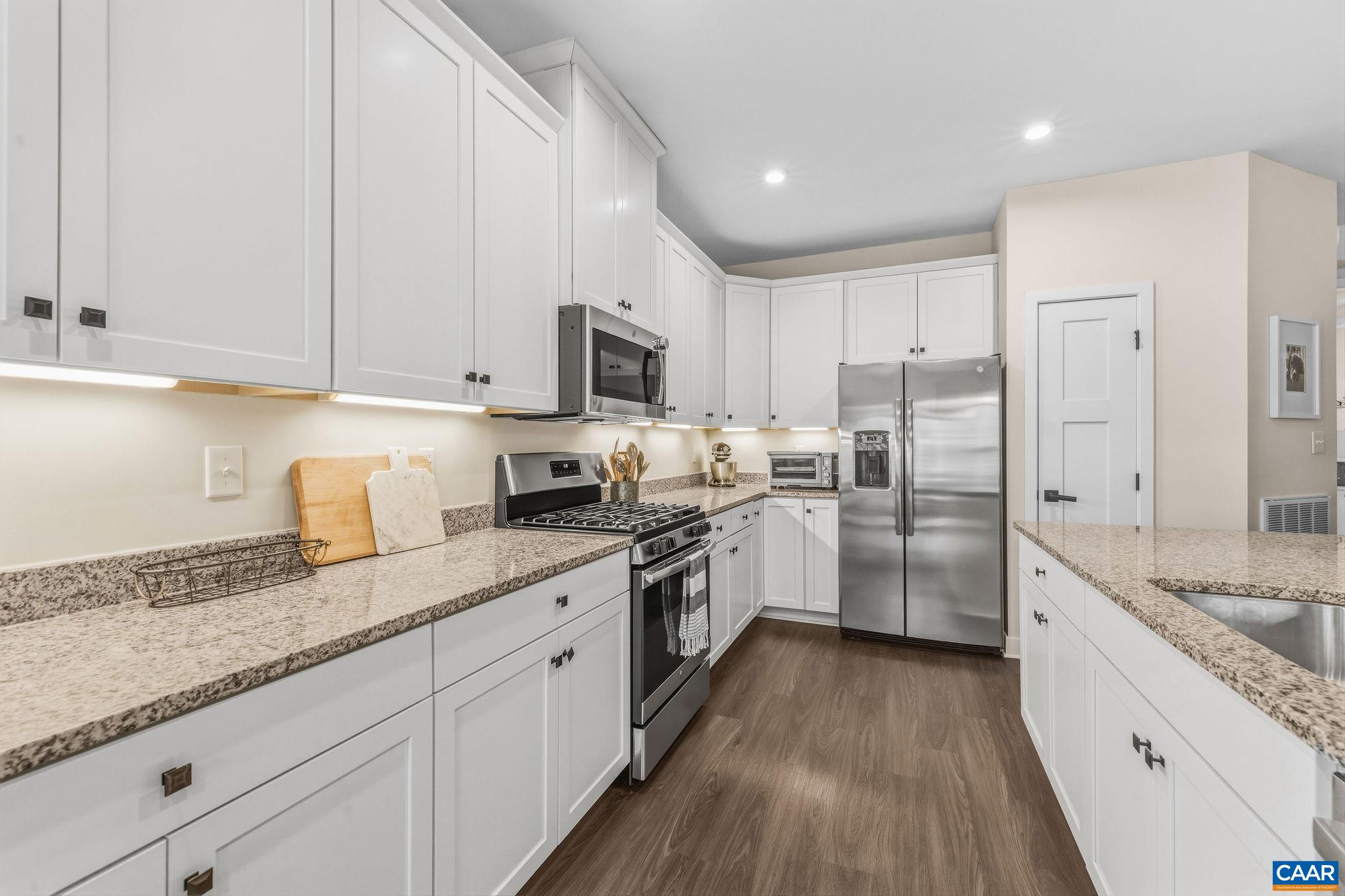 360 Winding Road Keswick, VA 22947 - Photo 22 of 48 a kitchen with granite countertop white cabinets and white appliances