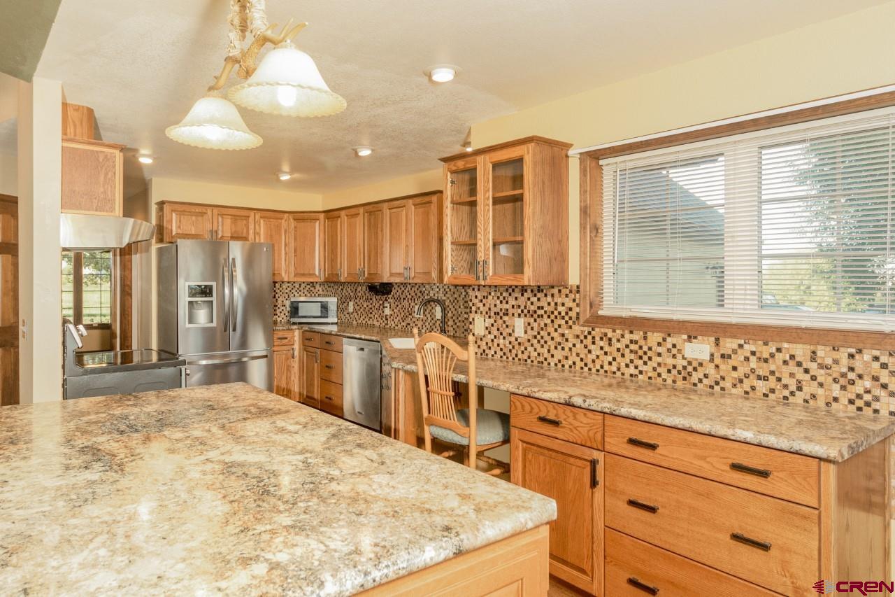 56731 A Road Delta, CO 81416 - Photo 8 of 28 a kitchen with stainless steel appliances granite countertop a stove a sink and a refrigerator