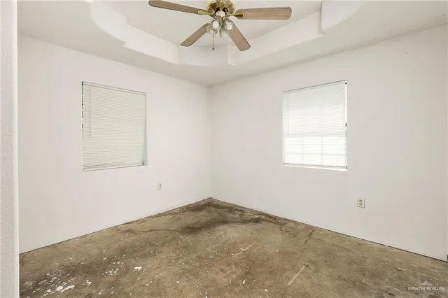an empty room with a window and a fan