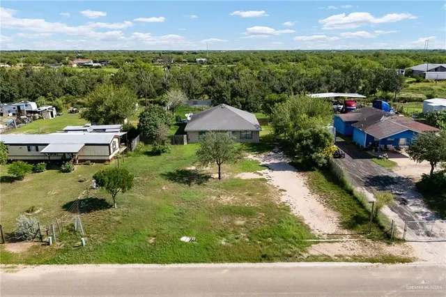 an aerial view of a house with a yard and lake view