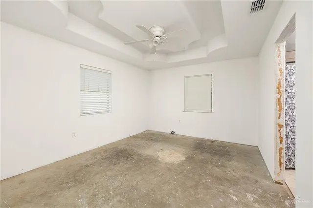 an empty room with a window and a ceiling fan