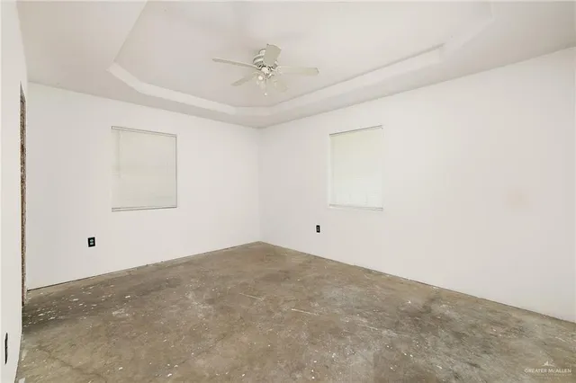 an empty room with a ceiling fan and a window