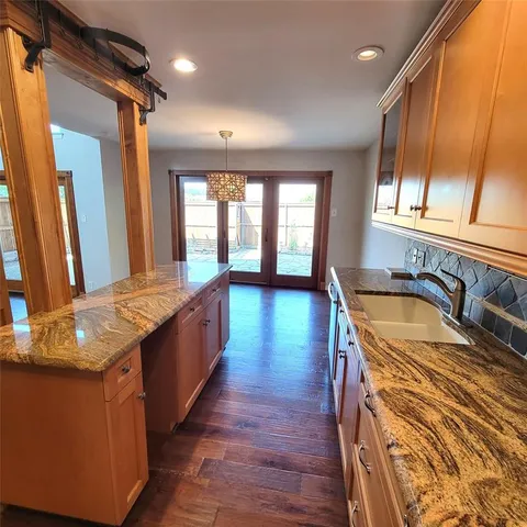 a large kitchen with stainless steel appliances granite countertop a lot of counter space and a sink