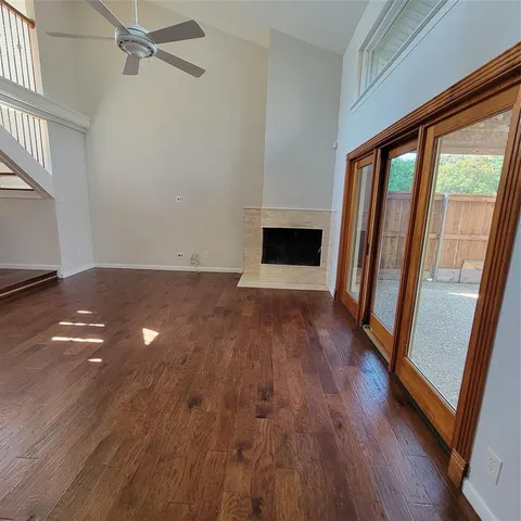 a view of empty room with wooden floor and fireplace