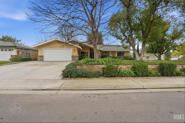 a view of a patio with table and chairs potted plants and large tree