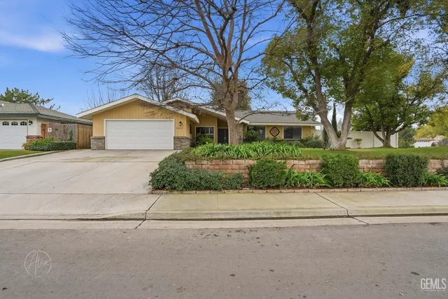 an aerial view of a house with a yard and a large tree