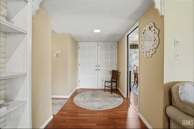 a view of a hallway with furniture and wooden floor