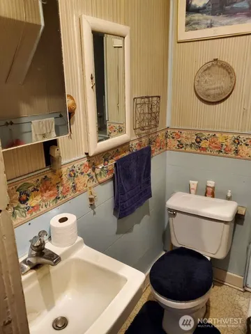 a bathroom with a sink a toilet and a mirror