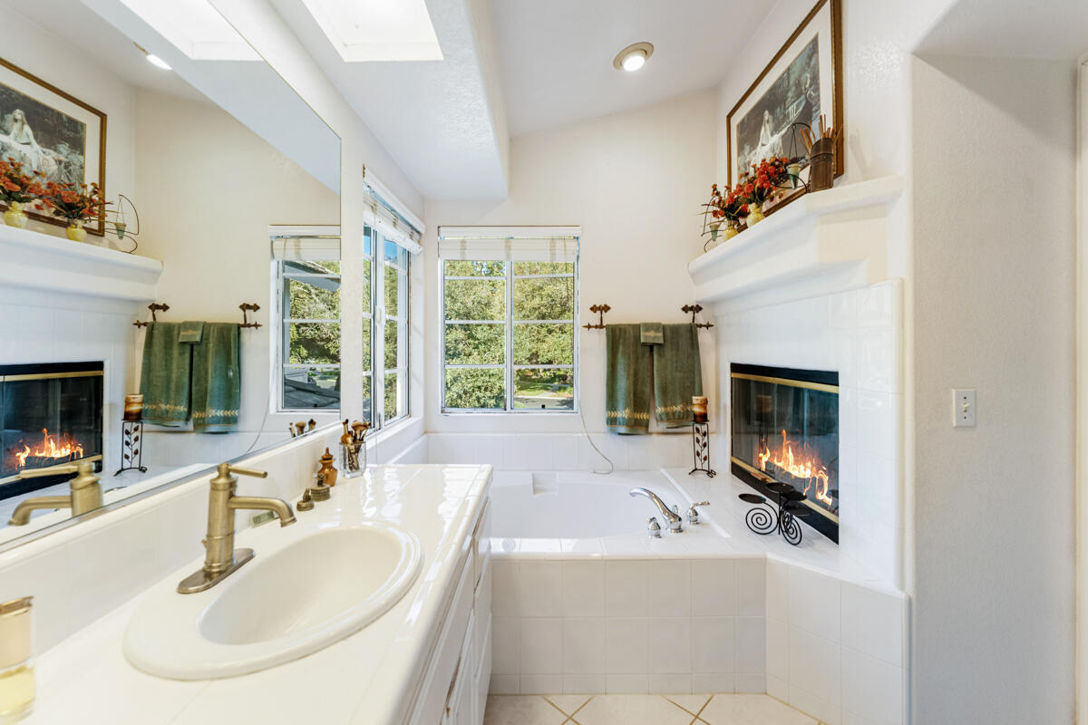 5019 Whitney Court Santa Barbara, CA 93111 - Photo 18 of 34 a spacious bathroom with a sink a fireplace and a large mirror