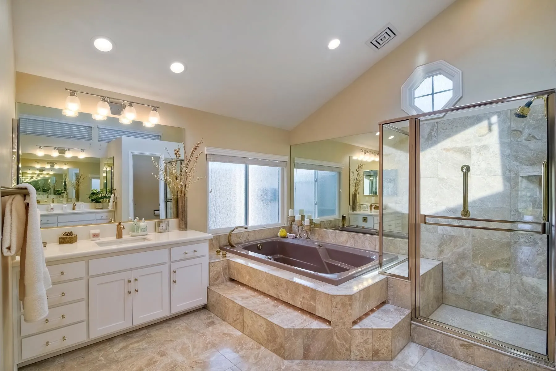 17533 St Andrews Drive Poway, CA 92064 - Photo 15 of 56 a bathroom with a sink a large mirror and a bathtub next to a window