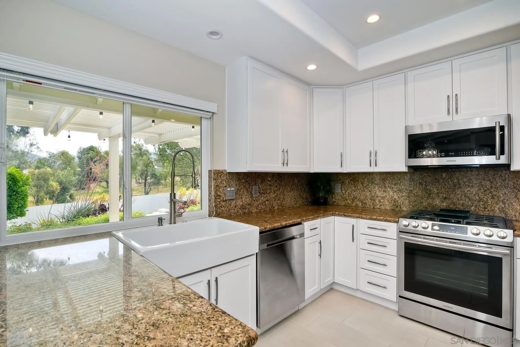 17533 St Andrews Drive Poway, CA 92064 - Photo 24 of 56 a kitchen with stainless steel appliances granite countertop a stove a sink and a microwave