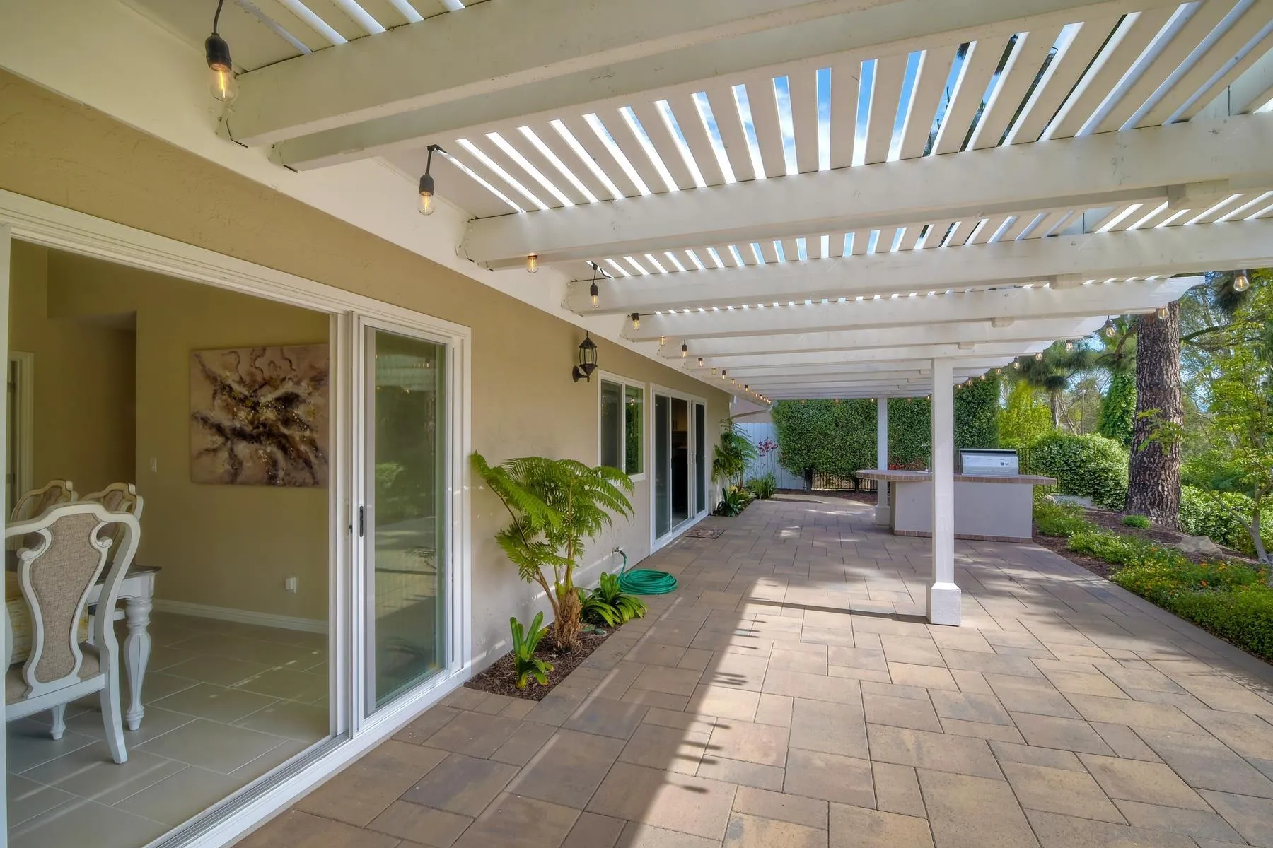 17533 St Andrews Drive Poway, CA 92064 - Photo 28 of 56 a view of a patio with table and chairs potted plants with floor to ceiling window