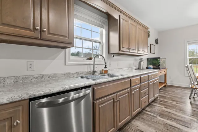 a kitchen with stainless steel appliances granite countertop a sink stove and cabinets