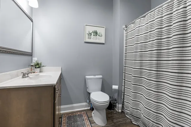 a bathroom with a toilet a sink and mirror