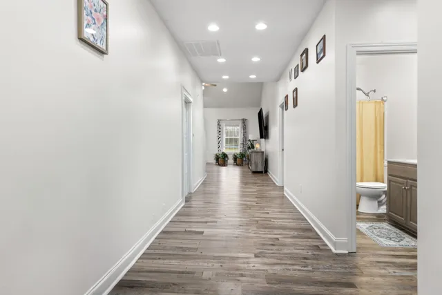 a view of a hallway with wooden floor and staircase