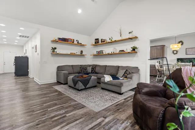 a living room with furniture and a wooden floor