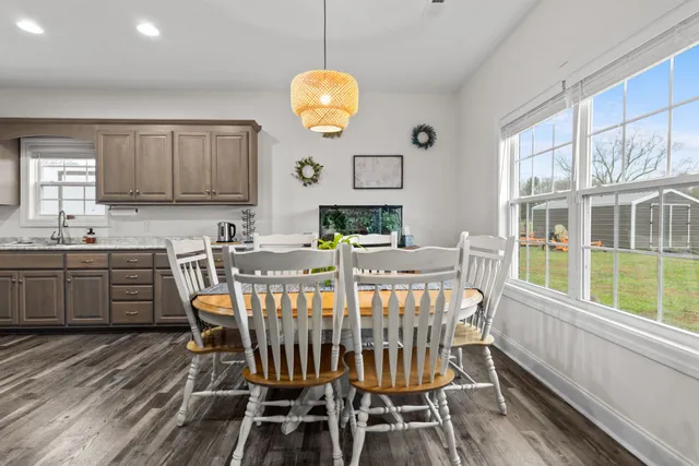 a view of a dining room with furniture a chandelier and wooden floor