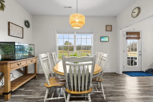 a view of a dining room with furniture a chandelier and wooden floor