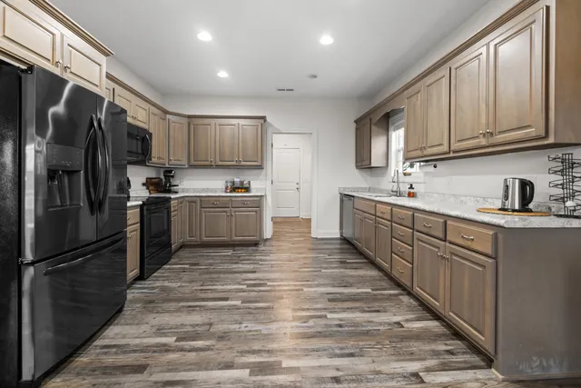 a kitchen with stainless steel appliances granite countertop a refrigerator sink and cabinets