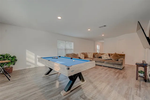 a living room with furniture a table and wooden floor