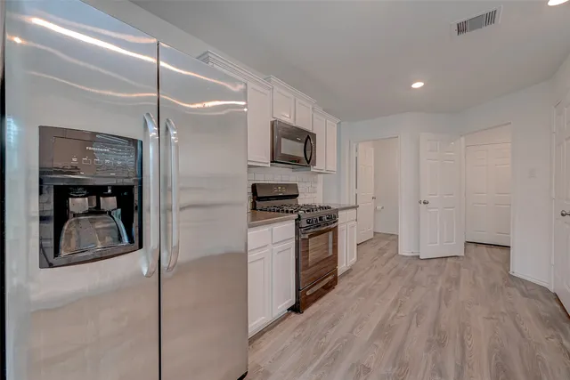 a kitchen with granite countertop a refrigerator and a stove