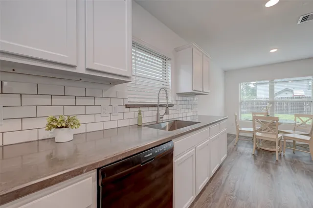 a kitchen with a sink a stove and cabinets