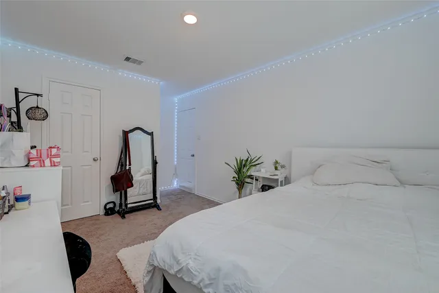 a bedroom with a bed and a potted plant